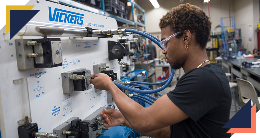 Student working on a hydraulic fluid switchboard