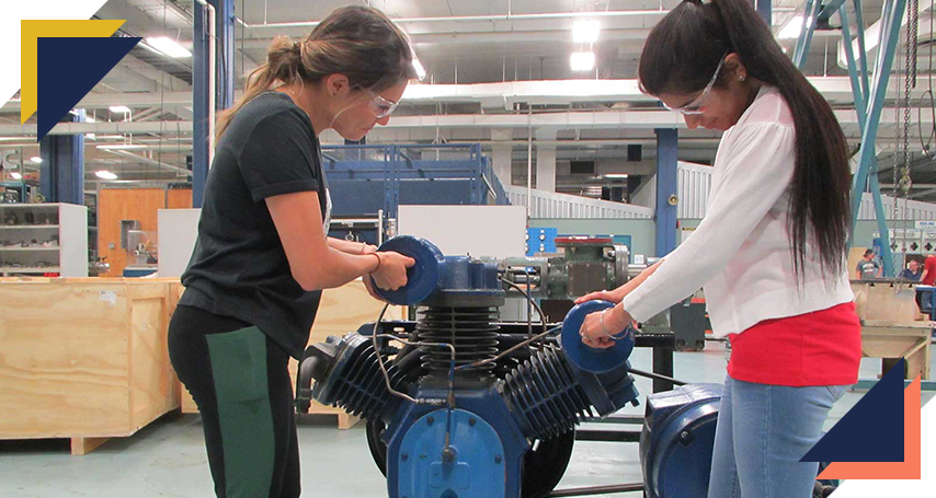 Two trades students taking apart a large engine