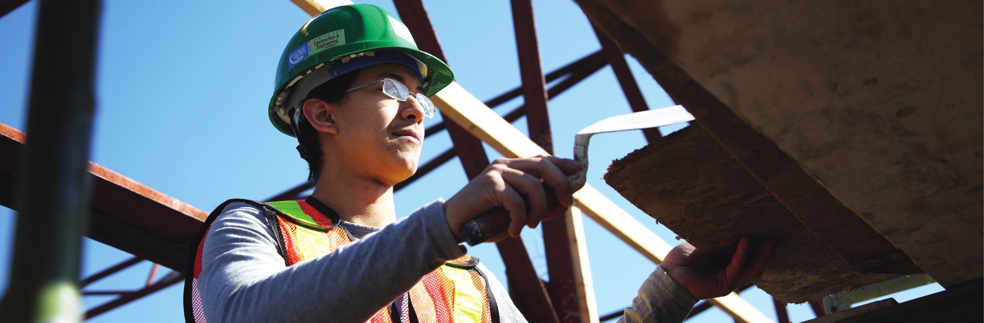 A construction trades worker molding a concrete column out of concrete on a jobsite