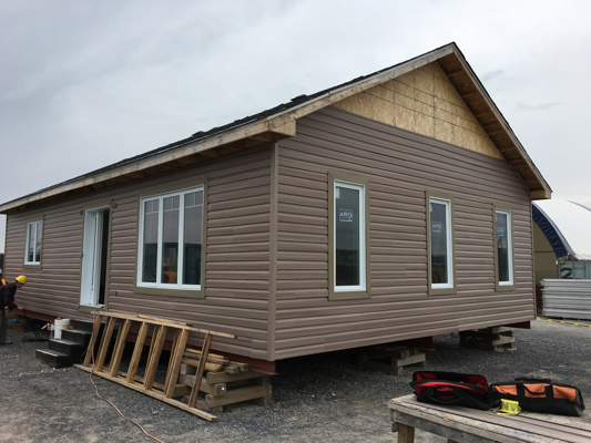 la cite construction students with an almost completed house built from scratch